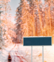 Blank green road sign in winter. Design template for information posts near a highway in winter.