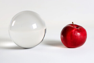 a bright red apple and a glass layer on a white background