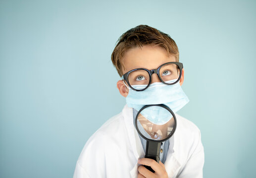 cool funny bub dressed as scientist with big magnifying glass and black glasses in front of blue background
