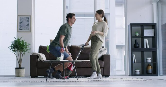 Music, dance and couple cleaning in a living room, happy, smile and having fun while bonding in their home. Housework, man and woman dancing to radio during spring cleaning, laugh and silly together