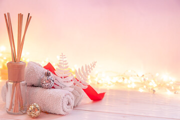 Christmas spa composition with incense sticks, towels and decor details.