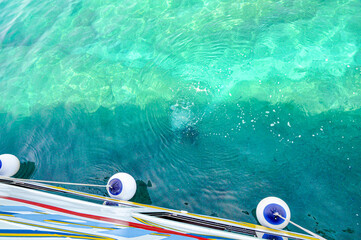 turquoise sea water with a hull of the yacht and fenders