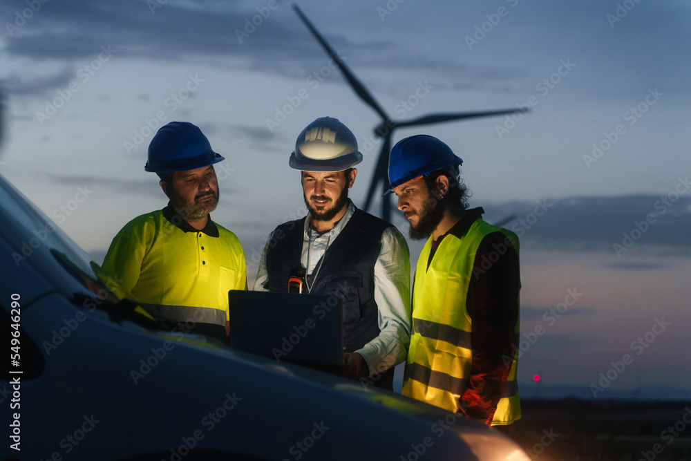 Wall mural electrical engineer and technical industry workers discussing project of electricity wind power stat