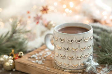 Christmas composition with a cup of coffee on a blurred background.