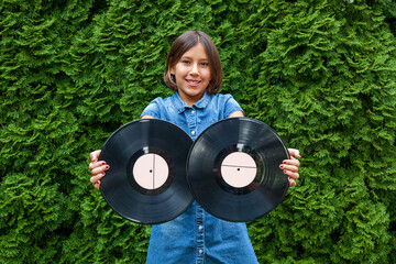 child girl holds vinyl records