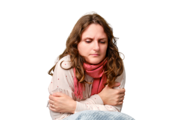 A woman is freezing from the cold sitting on a home bed, fever and high temperature, isolated on a white background. Adult ill woman with a red scarf, female aged 35 years