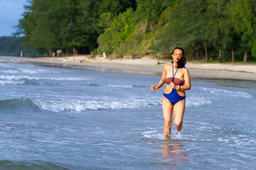 Fototapeta premium Woman body big with swimsuit walkin morning at beach