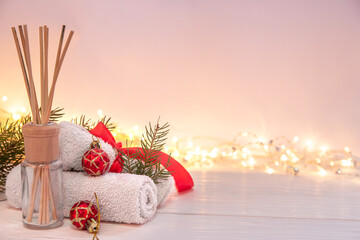 Christmas spa composition with incense sticks, towels and decor details.