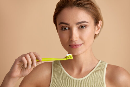 Healthy White Teeth. Closeup Portrait Of Beautiful Smiling Woman Holding Toothbrush With Toothpaste. Dental Health Care Concept. High Resolution Image 