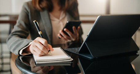 businesswoman hand working with new modern computer and writing on the notepad strategy diagram as concept