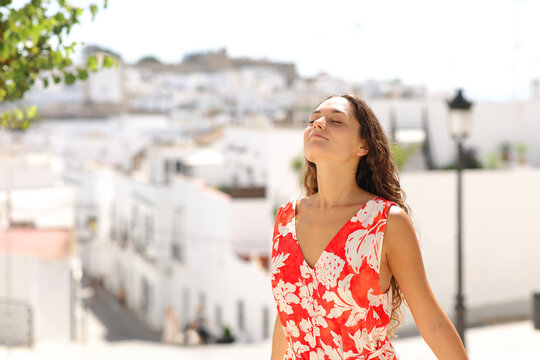 Tourist breaths fresh air in a white town on vacation