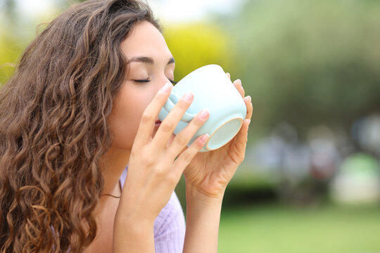 Woman drinking coffee in a park