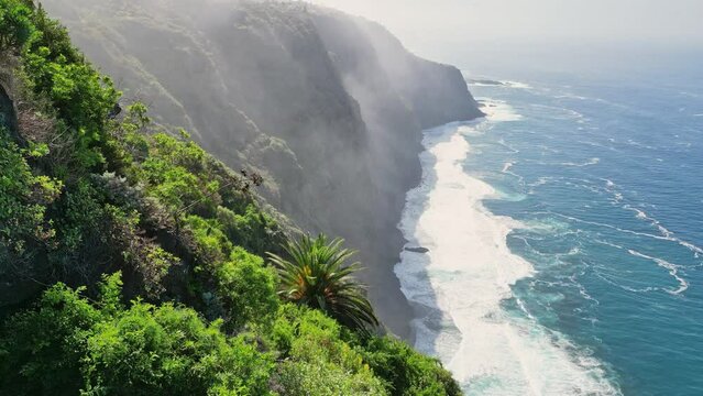 Aerial view from the viewpoint of a giant cliff with the powerful waves of the ocean breaking on a beautiful sunny day in Tenerife, Canary Islands