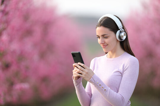 Woman listening to music in a pink field