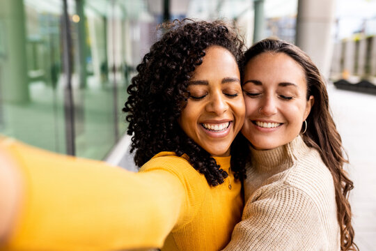 Happy Women With Eyes Closed Taking Selfie