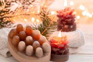 Christmas spa composition with incense sticks and soap on a blurred background.
