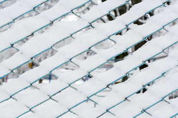 Obraz premium Mesh fence in the snow. winter