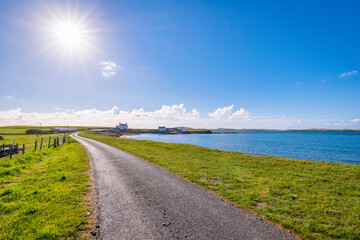 UK, Scotland, Melby, Sun shining over empty coastal road
