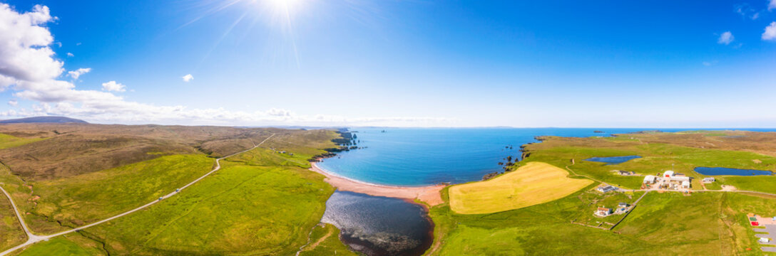 UK, Scotland, Aerial view of Saint Magnus Bay in summer with Drongs sea stacks in background