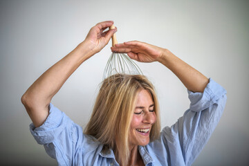 Happy woman enjoying scalp massage through massager at home