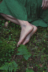 Close up feet on green forest ground concept photo. Conceptual style. Top view photography with moss on background. High quality picture for wallpaper, travel blog, magazine, article
