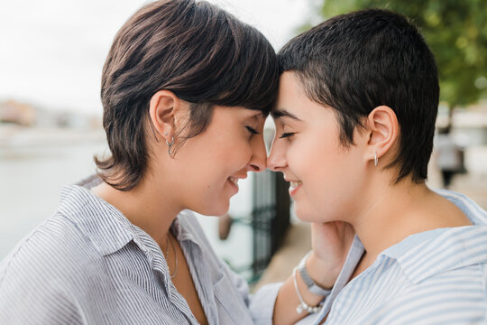 Lesbian couple nuzzling with eyes closed