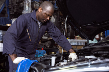 Black mechanic man fixing car in auto repair shop, Car Mechanic Concept