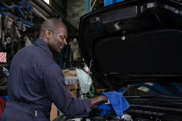 Fototapeta na wymiar Black mechanic man working in auto repair shop, Car Mechanic Concept