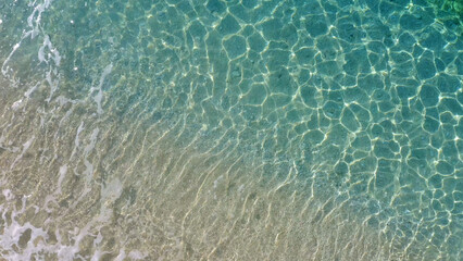 Top view of yellow sandy beach with white foam waves. Ocean nature background. Summer time paradise.