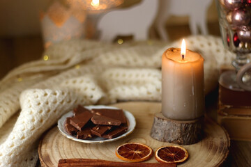 Cup of tea or coffee, various sweets and spices, Christmas decorations, comfy blanket, books and glasses. Selective focus.