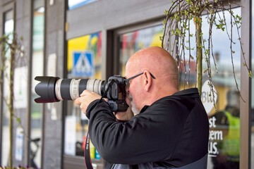 Bald male middle-aged photographer in profile