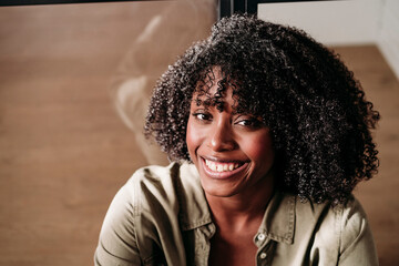 Smiling woman with curly hair at home