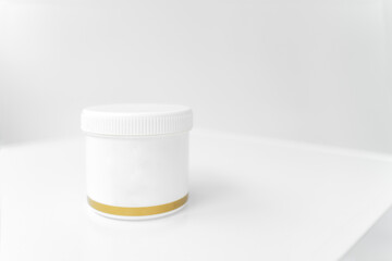 jar with white lid for cream with gold edging isolated on white background