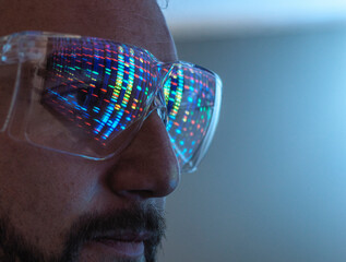 Scientist wearing protective eyeglasses analyzing DNA data in laboratory