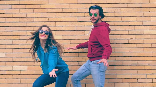 funny couple performs synchronized steps in hip hop style in front of the camera