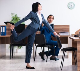 Obraz premium Two employees doing sport exercises in the office