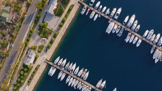 Aerial drone view of yacht and sailboat parking in marina. Top view of many white boats in sea water. Yachting concept.