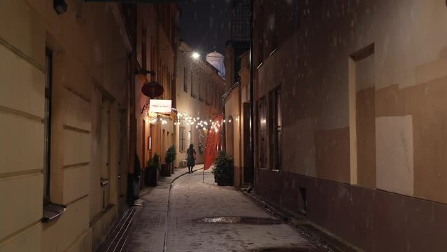 Winter snowfall on the streets of Vilnius. 4K video with calm beautiful snow falling from the sky during an evening in Lithuania, 2022.