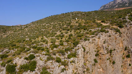 Fototapeta na wymiar Wild rocky mountain on the Mediterranean coast. Clear blue sky in the background. Nature landscape.
