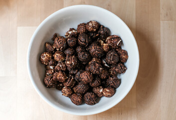 chocolate popcorn in a white bowl top view, selective focus
