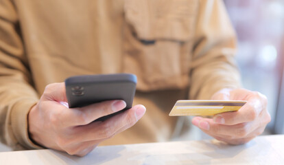 Man using mobile phone to pay with credit card via mobile banking. banking and e commerce concept. mobile payment with wallet app technology, digital money transfer, shopping smartphone application.
