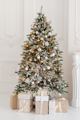 A beautifully decorated room with a Christmas tree with gifts underneath. Interior Christmas. magic luminous tree, new year. Soft selective focus.