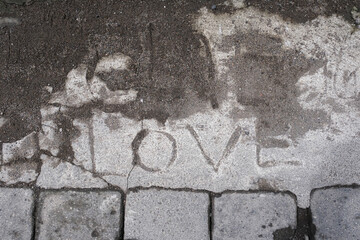Dirty gray concrete pavement with word Love carved background texture