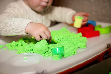 girl plays with kinetic sand. child builds shepherds in form of letters of sand. Early development...