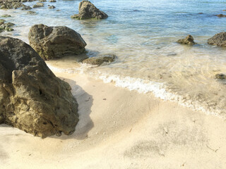 Tropical beach with panoramic views and waves, rocks and sand background