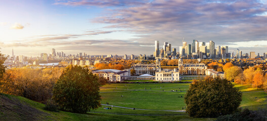 Panoramic view of the London skyline from Canary Wharf to the City seen from Greenwich Park during golden autumn sunset time - obrazy, fototapety, plakaty