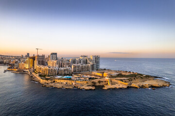 Obraz premium Aerial view of Sliema in Malta, skyline at sunset, blue sea waters and sky. Aerial drone view