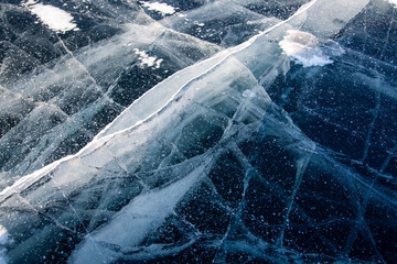 Ice on a frozen river in winter. Ice texture. Dark blue ice with white cracks. With copy space.