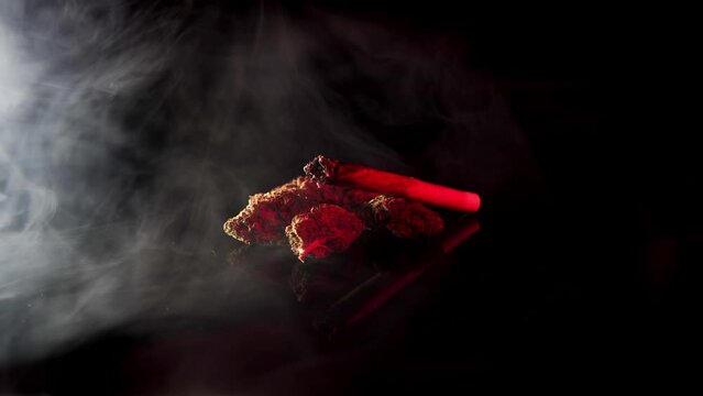 Beautiful smoke over hemp flower buds and joint with red and blue police lights