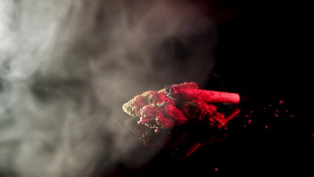 Blue and red police lights with smoke over ganja weed buds and cannabis joint